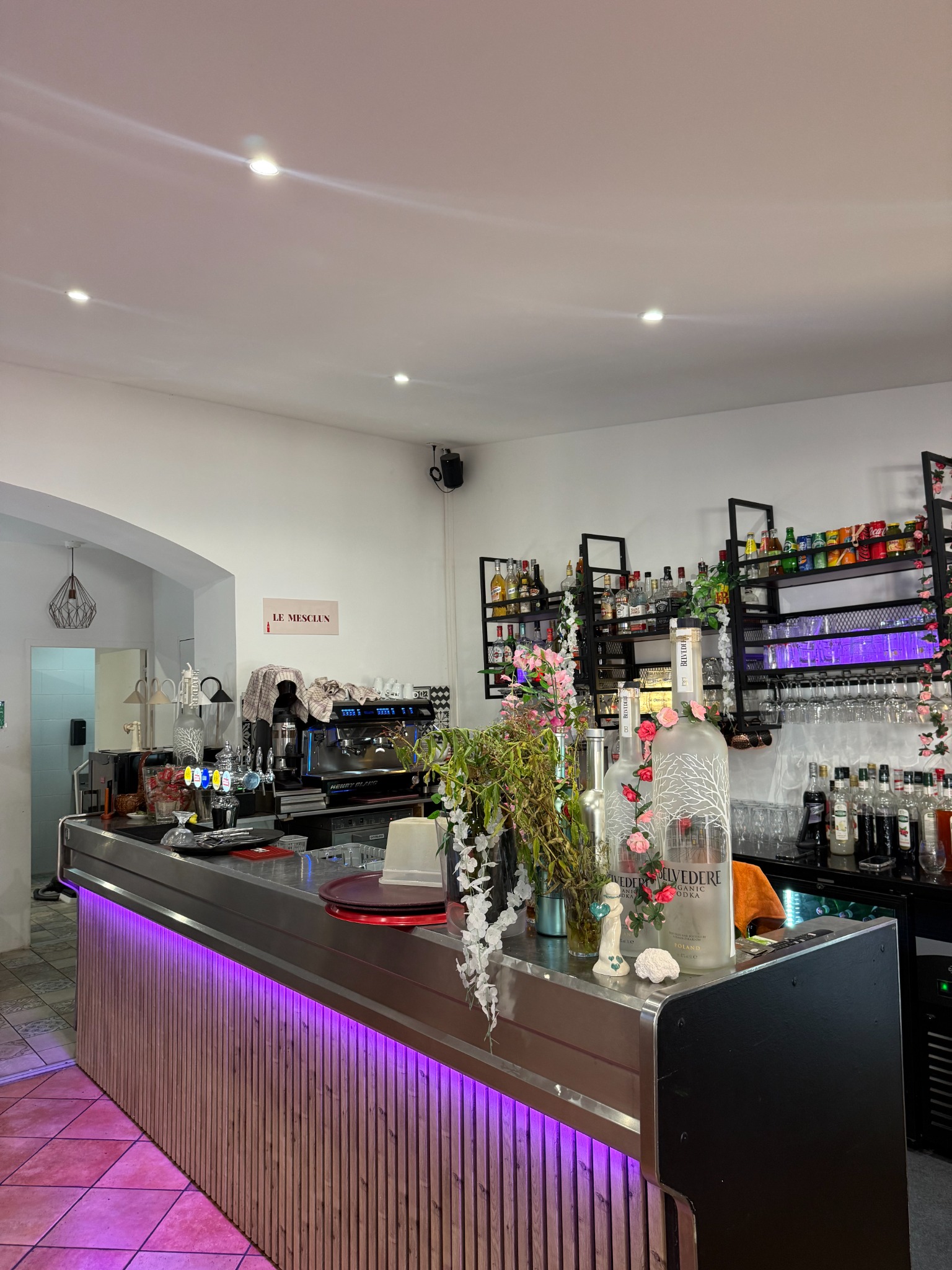 Le bar du Mesclun, son comptoir en bois et sa décoration fleurie